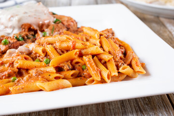 A view of penne pasta and chicken parmigiana.