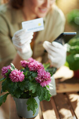 Smiling woman in rubber gloves in sunny day shop online