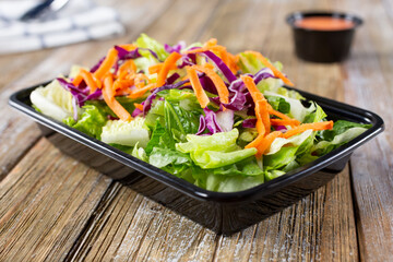 A view of a common side garden salad in a to-go container.
