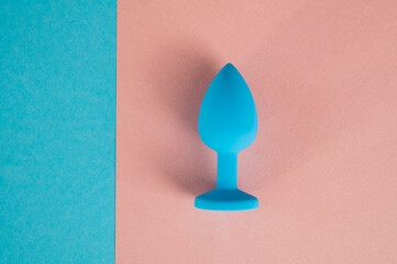 Blue anal plug on a pink background. Plastic sex toy for alternative sex. Copy space.