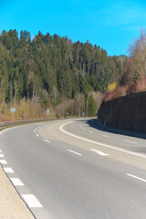 vierspurige stra&szlig;e mit einer mauer, mit b&auml;umen und blauem himmel