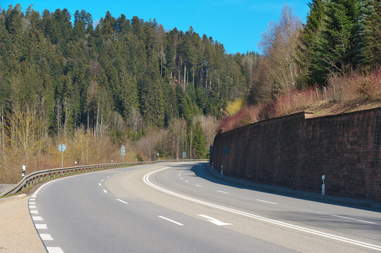 vierspurige stra&szlig;e mit einer mauer, mit b&auml;umen und blauem himmel