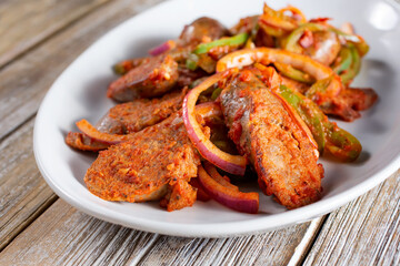 A view of a plate of sausage and peppers.