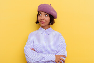 Young mixed race woman wearing a beret isolated on yellow background dreaming of achieving goals...