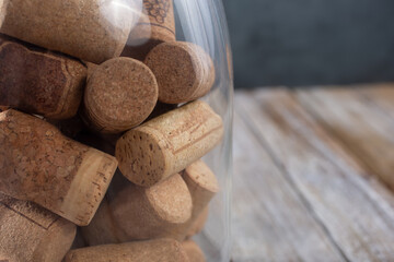 A closeup view of a jar of wine corks, sitting on the left side of the frame.