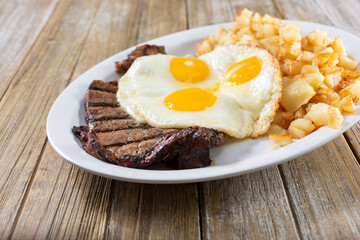 A view of a breakfast plate of steak and eggs.