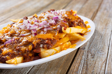 A view of a plate of chili cheese fries.