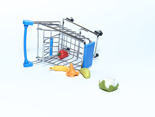 An upturned blue grocery cart with groceries. Isolated on a white background. The concept of sales and purchases.