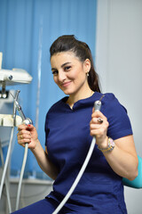 Portrait of female doctor dentist holding working tools and smiling.