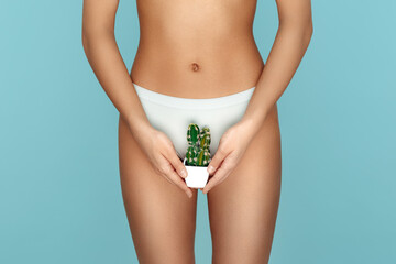Close-up image of asian young woman body holding cactus over blue background. Depilation concept.