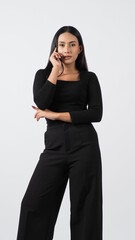 Young woman posing in black shirt and pants in the studio on white background. Sexy Asian black hair girl with full lips pose to camera. Attractive female with big breast. posing in studio shooting.
