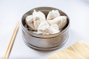 A view of a steamer container featuring BBQ pork buns.