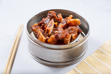 A view of a steamer container featuring beef short ribs.