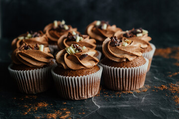 Delicious chocolate cupcakes. Cupcakes with chocolate cream and strawberry filling. Cupcakes on the table