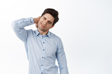 Corporate man, office employee massage neck, having back pain, grimacing from painful discomfort, standing against white background