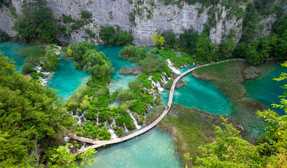 Top view of  Plitvice Lakes with waterfalls and wooden walkways with tourist