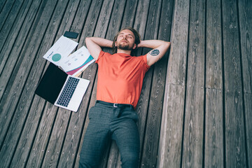 Man resting on wooden platform falling asleep