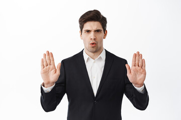 No, stop this. Serious corporate man, businessman in suit frowning, blocking offer, rejecting,...