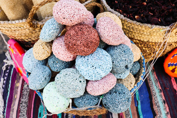 multicolored pumice stone in wicker baskets on wooden tables