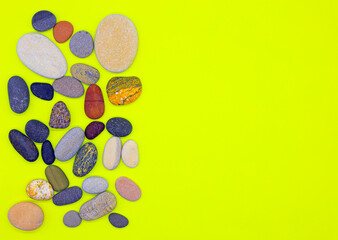 Obraz na płótnie Canvas Layout of sea pebbles on a yellow background.