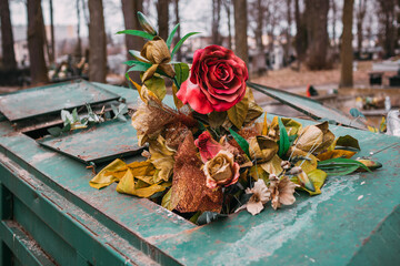red funeral artificial flower in a garbage container