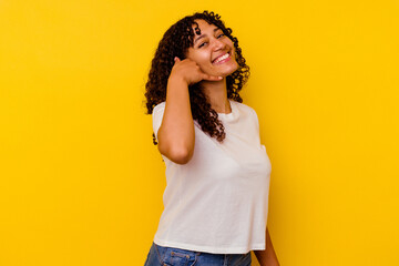 Young mixed race woman isolated on yellow background showing a mobile phone call gesture with fingers.