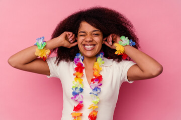 Young african american woman wearing a hawaiian stuff covering ears with hands.