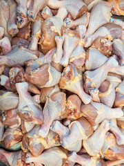 Raw chicken legs pile up on stall
