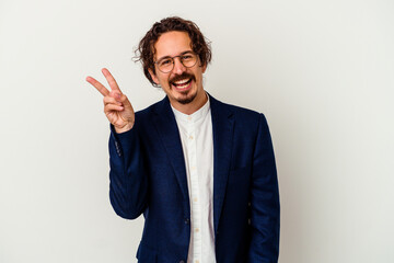 Young business man isolated on white background joyful and carefree showing a peace symbol with fingers.