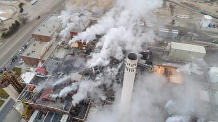 smoke coming out of a factory that is producting goods