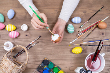 woman painting eggs for happy easter