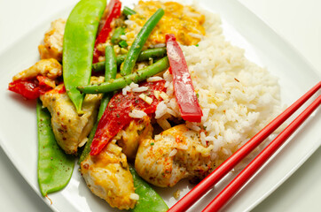 Chicken breast pieces in a Thai red curry sauce made with coconut cream, red chillies, lemongrass, lime leaf, with fragrant rice, red peppers, mange tout, and green beans