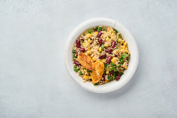 Mexican black bean corn quinoa salad with caramelized lemon in old vintage clay bowl on a light gray concrete background. Traditional Mexican cuisine dish. Top view, mock up.