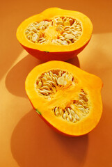 Halves of pumpkin on an orange background.
