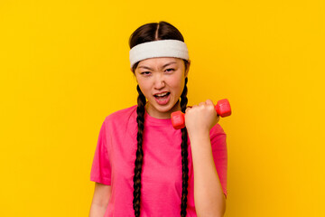 Young sport chinese woman isolated on yellow background