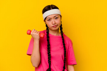 Young sport chinese woman isolated on yellow background