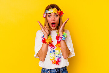Young caucasian woman celebrating a hawaiian party isolated on yellow background surprised and shocked.