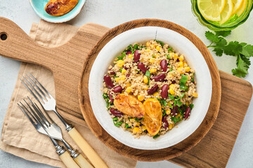 Mexican black bean corn quinoa salad with caramelized lemon in old vintage clay bowl on a light gray concrete background. Traditional Mexican cuisine dish. Top view, mock up.