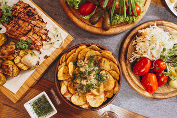 Assorted delicious grilled meat with vegetable and herbs on rustic table