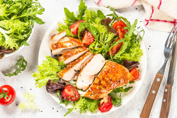 Grilled chicken with fresh salad at table.