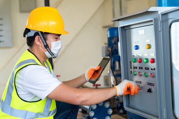 Asian engineer check panel broad of booster pump controller at water plant