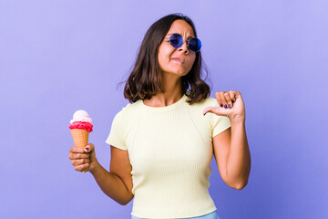 Young mixed race woman eating an ice cream feels proud and self confident, example to follow.