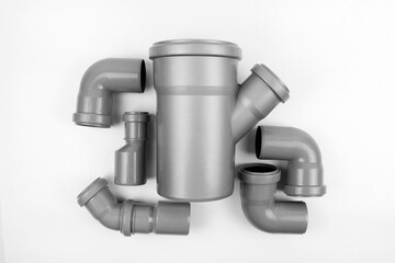 PVC plastic water pipes in gray color, insulated on a white background. The concept of installation, replacement of plastic pipes, plumbing. Top view. Flatlay. Copyspace.