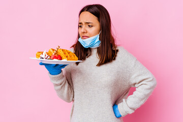 Young surgeon woman holding a waffle isolated