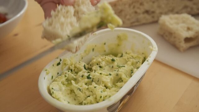 Typical Madeiran bread bolo do caco spread with butter and parsley. Handheld shot