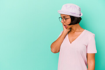 Young mixed race woman isolated on blue background being shocked because of something she has seen.