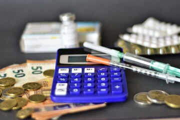 calculator, money, syringes and pills