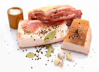 raw pork meat and lard with salt, spices and garlic on white background