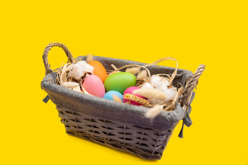 Easter Eggs in basket on yellow background