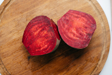 two pices raw beetroot on wooden cutting board